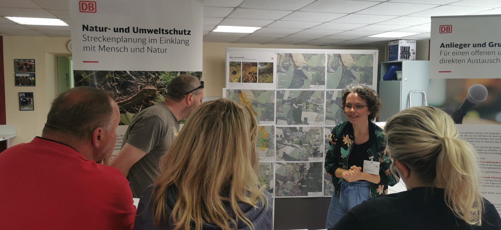 Menschen versammeln sich vor einem Infostand zu Umwelt- und Naturschutz.
