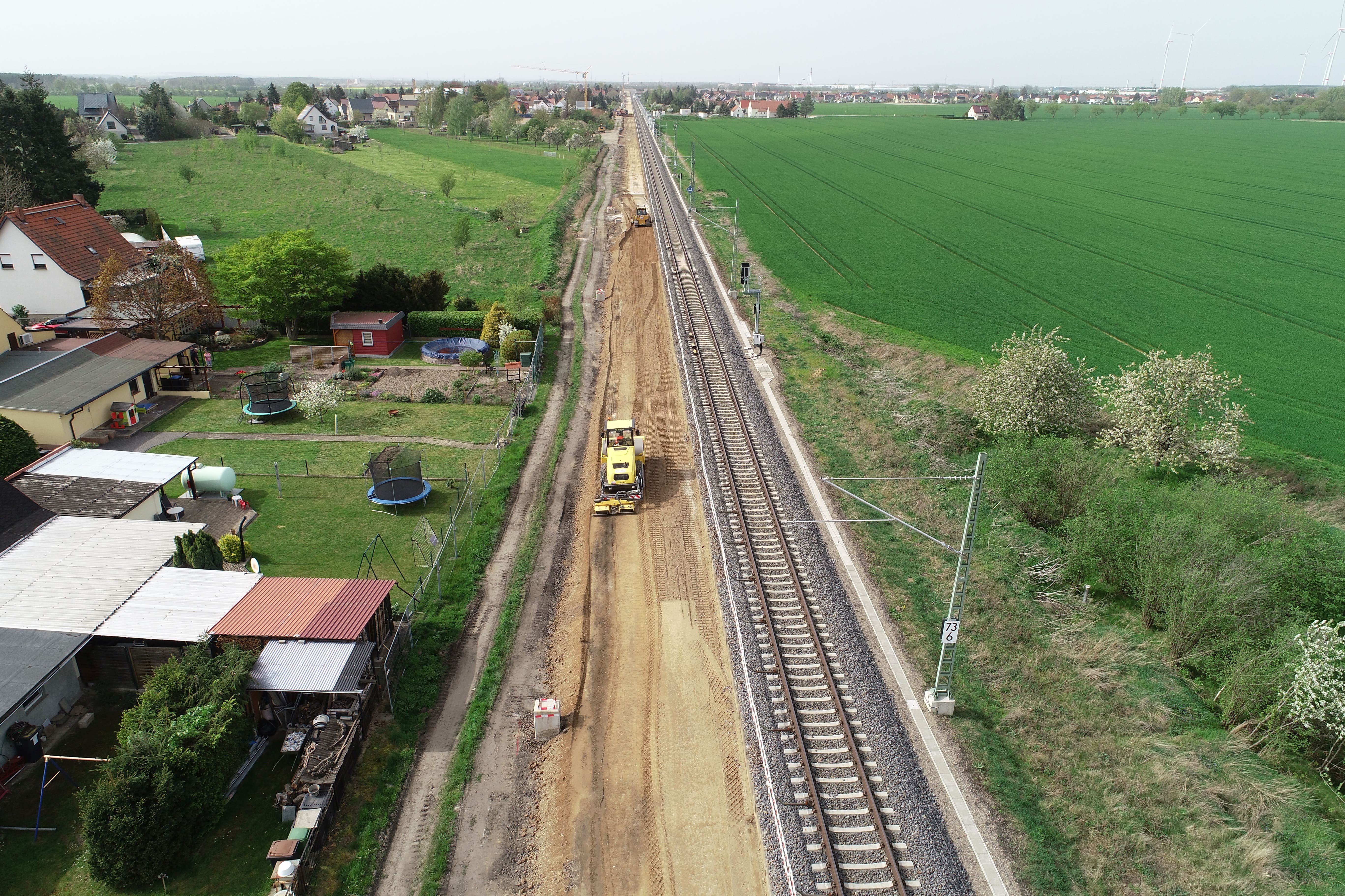 Eine aktive Baustelle an der Bahnstrecke bei Glaubitz. Im Bild sind Gleise zu sehen, daneben arbeiten mehrere Baumaschinen.