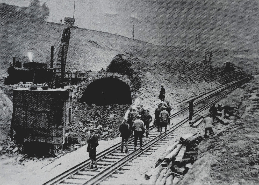 Darstellung des Rückbaus des Oberauer Eisenbahntunnels. Arbeiter entfernen Teile der Tunnelstruktur.
